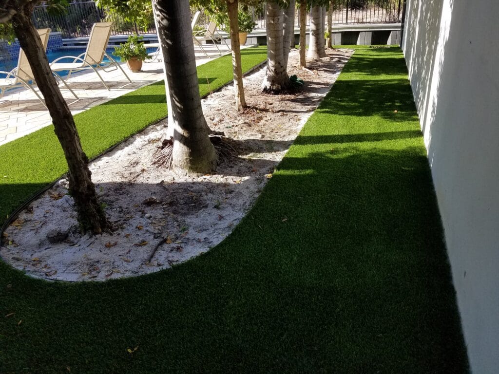 a lawn with trees and a pool in the background smart synthetic turf